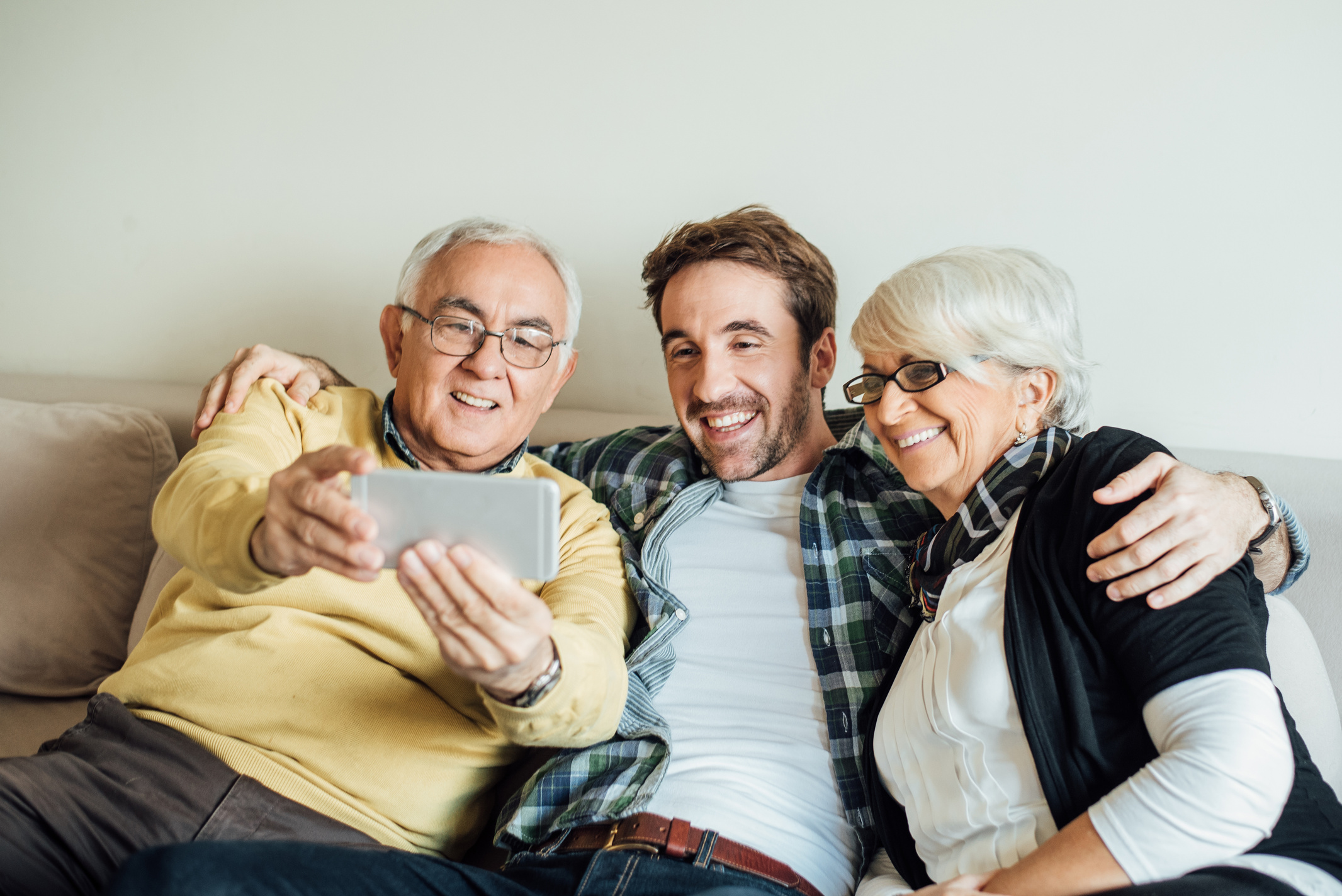 Son taking selfie with his old parents his parents
